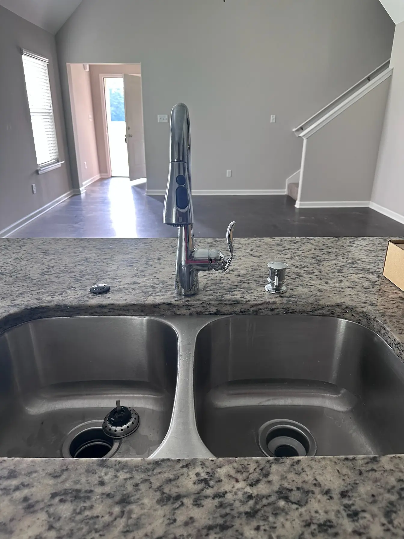 Finished kitchen faucet and double stainless sink in a newly built home